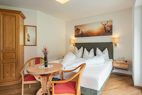 Doppelzimmer mit Holzelementen und einem modernen Bett