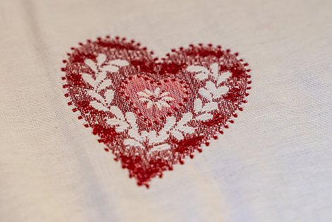 Detailaufnahme gesticktes Herz auf Tischdecke